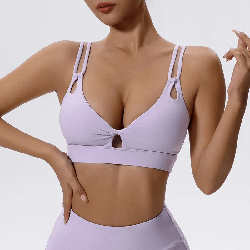 Purple strappy sports bra with cut-out details, showcasing a stylish and supportive design for workouts or casual wear.